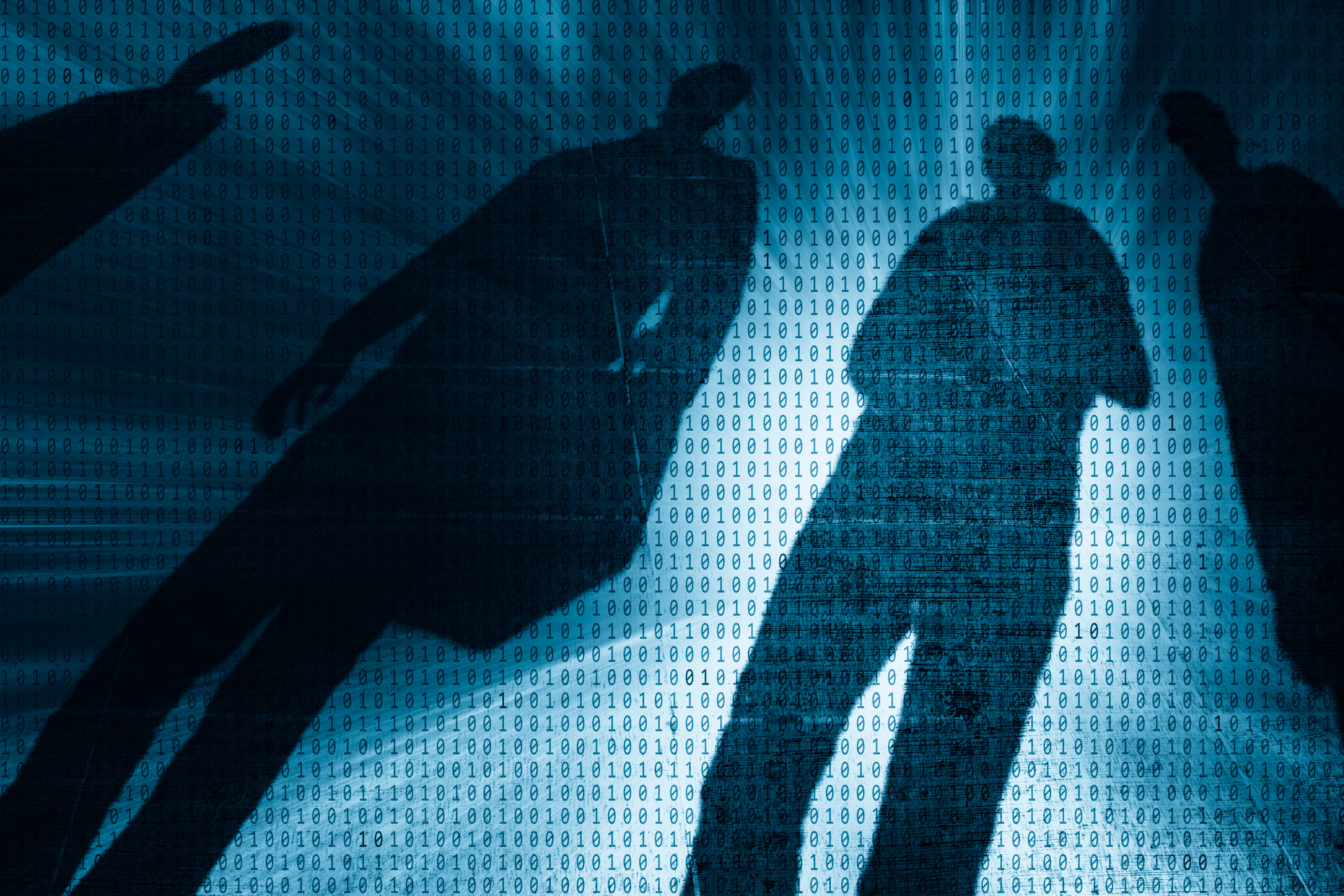 Dunkle Personensilhouetten hinter einer Ebene aus Binärcode symbolisieren Cyberbedrohungen, Datenrisiken und digitale Sicherheitsherausforderungen.