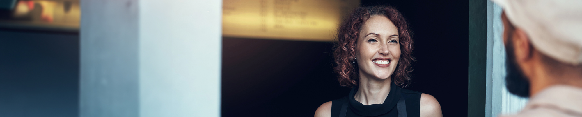 Eine Kundin nimmt freudig ein Paket entgegen