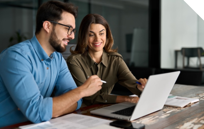Zwei Mitarbeitende vor einem Rechner