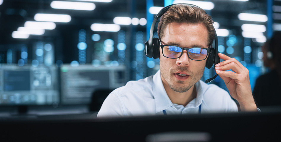 Mann mit Kopfhörer in einer IT-Hotline