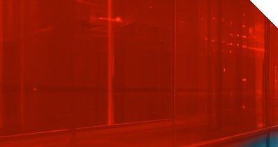 Ein gläserner Korridor mit schemenhaften IT-Systemen in rotem Licht 